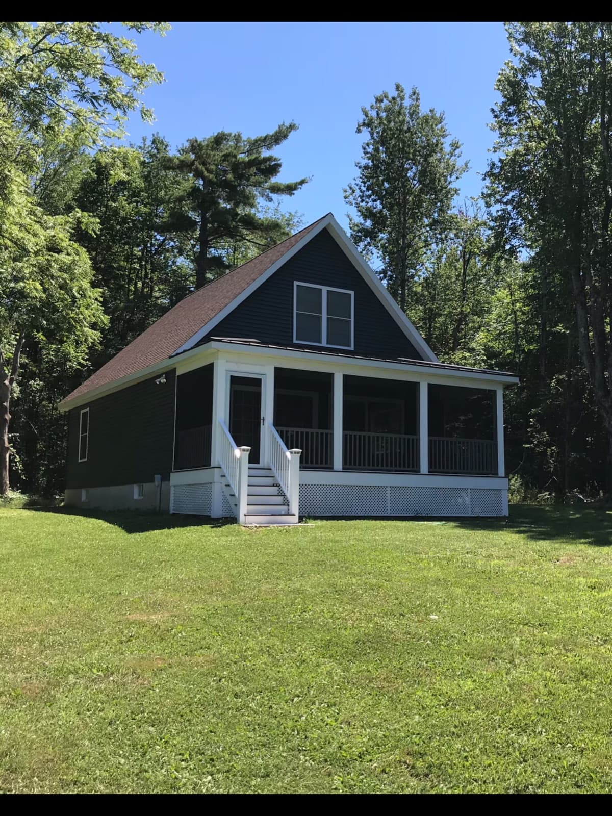 The lakefront cottage and its screened porch on a summer day