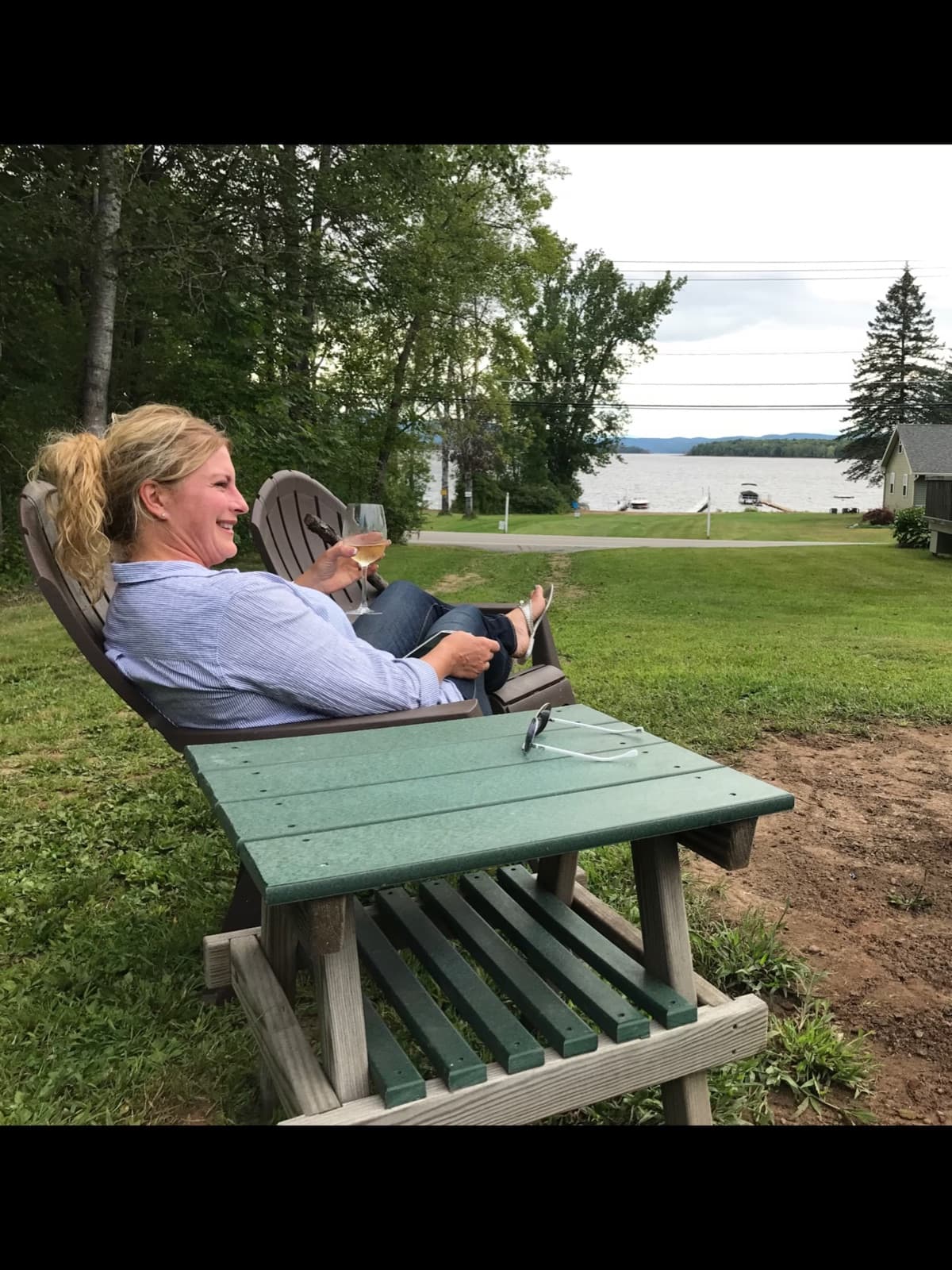 Happy hour in an Adirondack chair by the fire pit with a lake view