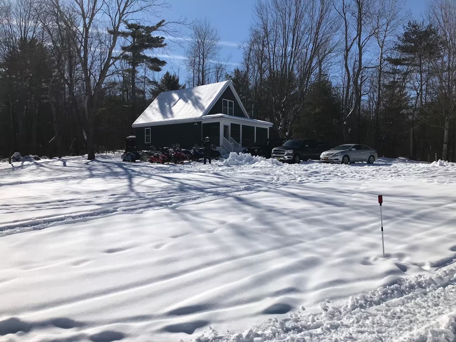The cottage under snow, snowmobiles at the ready